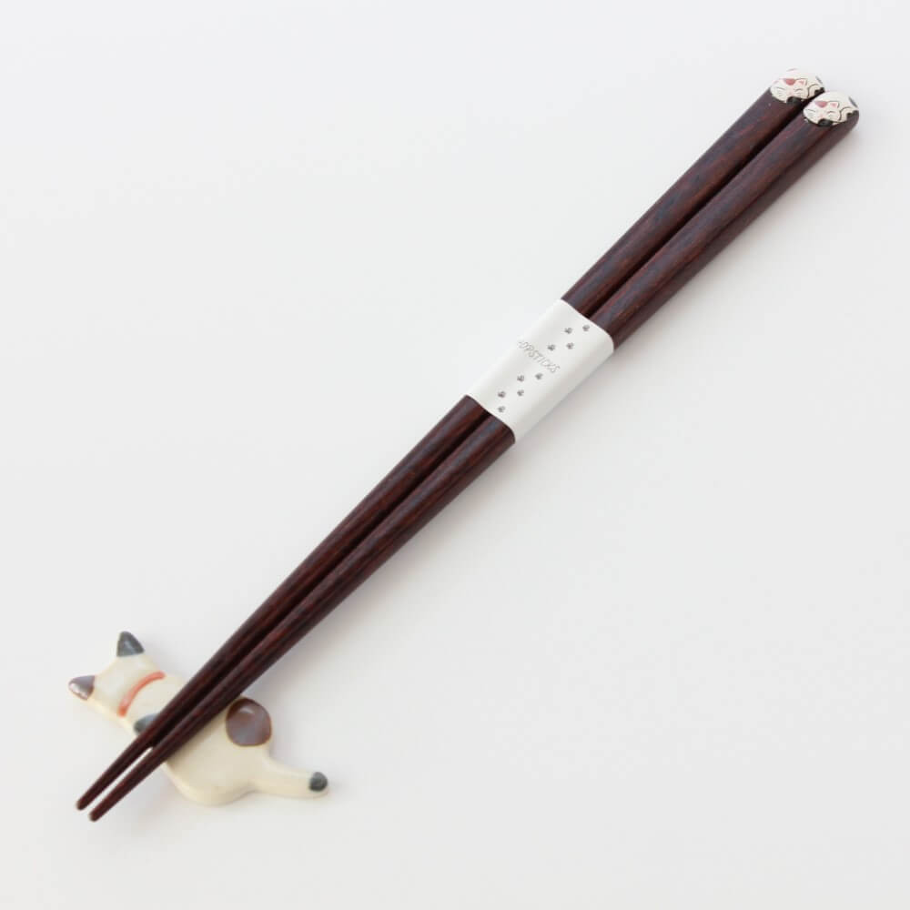 calico cat chopsticks on cat rest