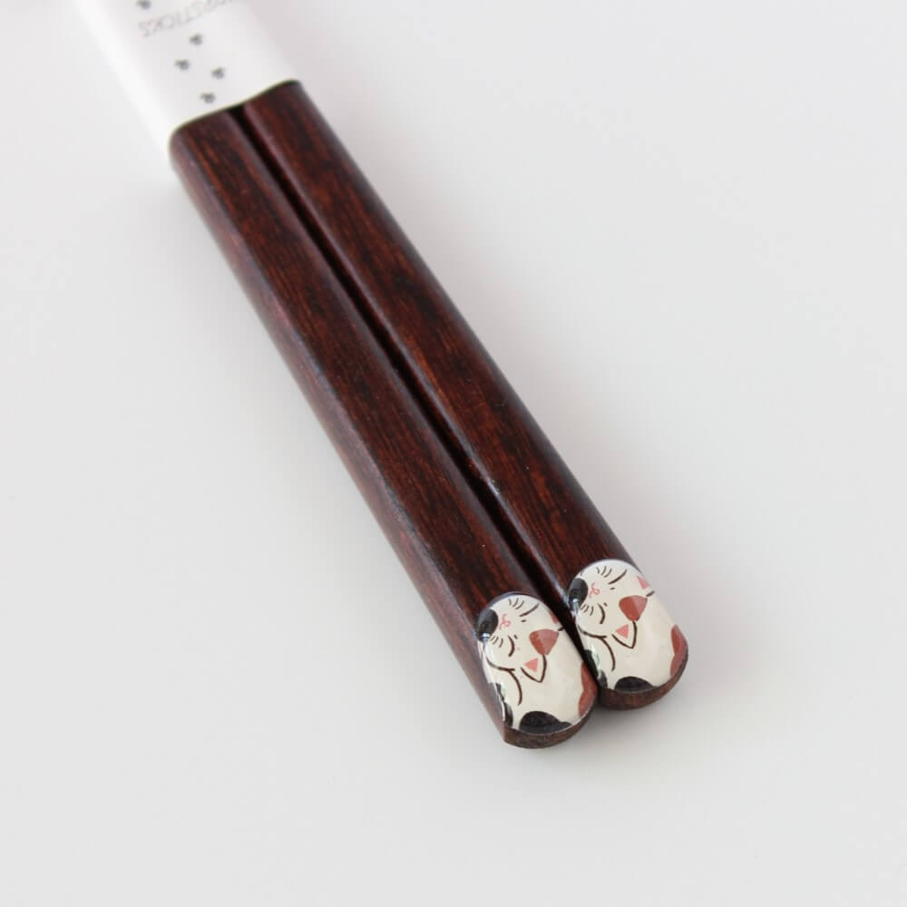 close up chopsticks handle tips showing calico cat